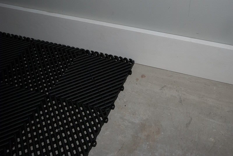 DSC_0592.jpg - A close up of the Ribtrax tiles shows one of the loop edges.  Downward facing pegs on the next tile will engage the loops, locking them together.  This is why they're installed from back-left to front-right.