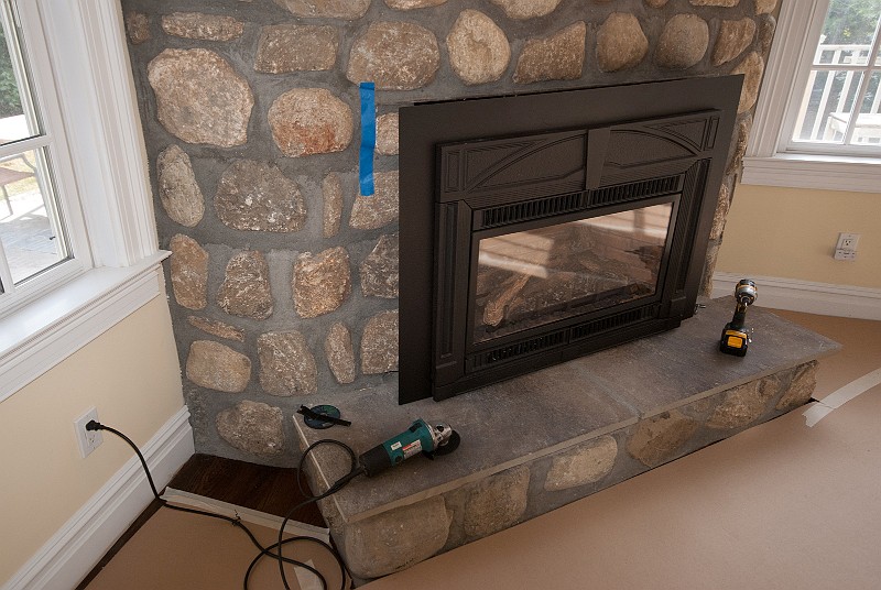 DSC_0931.jpg - There is one protruding stone on the face of the fireplace that prevents the gas insert from fitting flush.  It has bothered me for a year and a half.  I marked it with blue tape.  My grinder is at the ready.