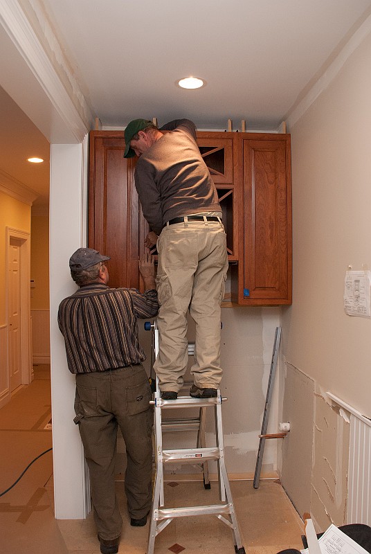 DSC_1214.jpg - Misha works on mounting the upper butler pantry cabinet.