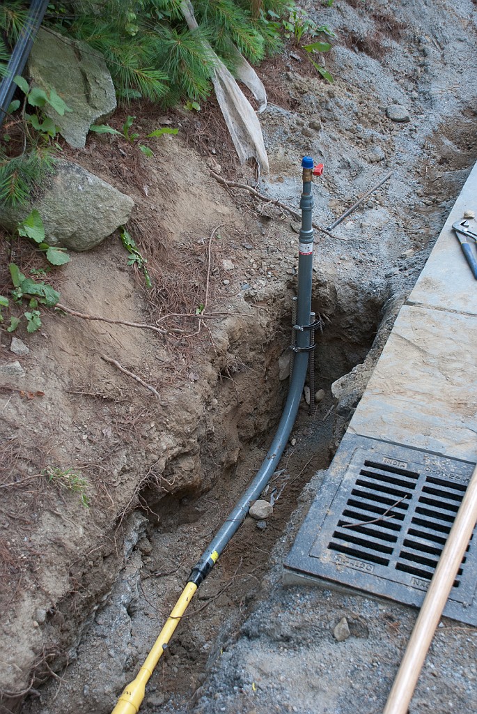 DSC_8684.jpg - The plumber has placed the new gas pipe in the trench.  Austin & I get to finish the job.
