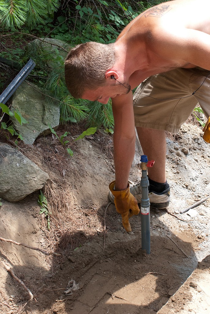 DSC_8689.jpg - Austin is refilling and tamping the trench.  Here he shows that the gas pipe is still plumb.